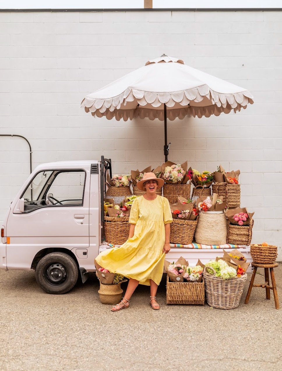 Jillian at the Eleven Acres flower stand with her pink truck and scalloped umbrella
